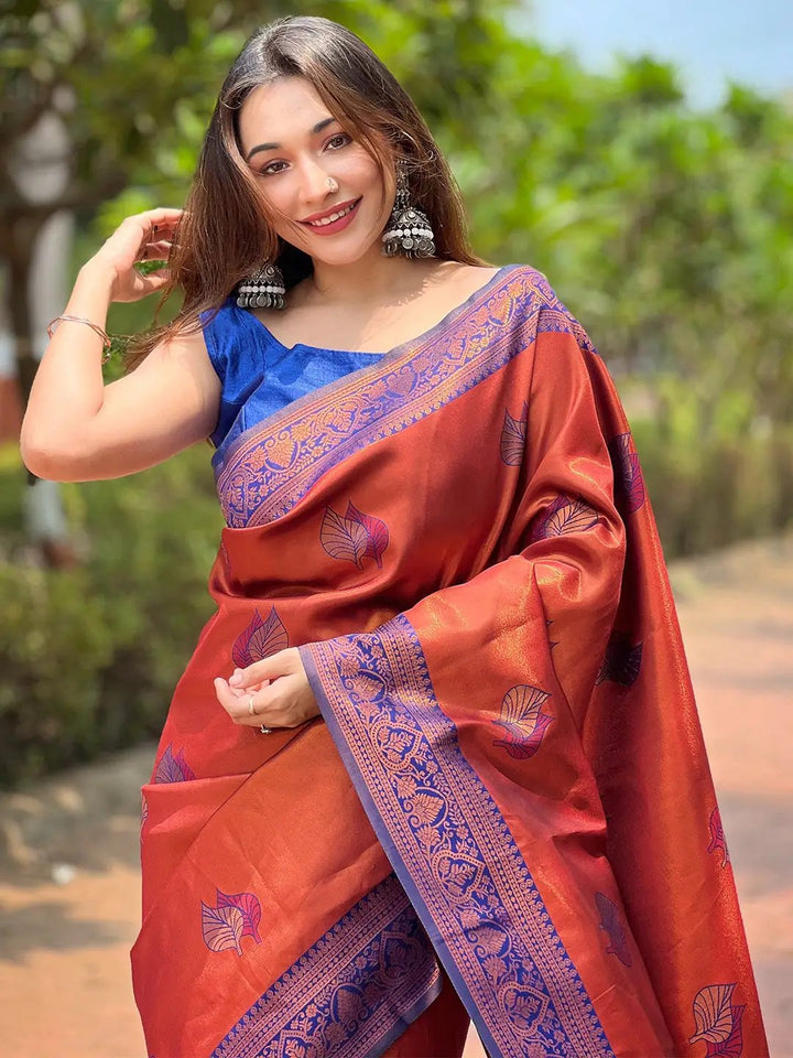 Rust Red Kanjivaram saree with gold zari, worn by a woman.